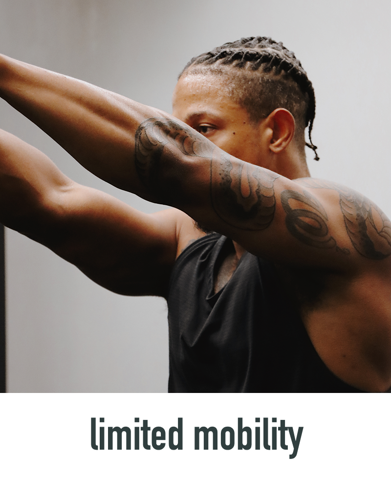 Man with tattoos stretching his arm against a neutral background, with 'limited mobility' text overlay.