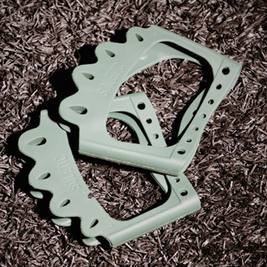 Light green plastic tool on a brown mulch background